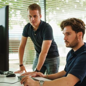 Twee werknemers van Merk-Echt controleren merknaam