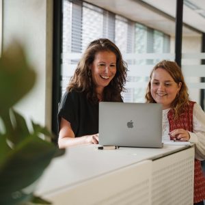 Benelux merkregistratie Twee medewerkers kijken op laptop in kantoor omgeving