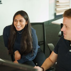 Twee medewerkers van Merk-Echt kijken op computerscherm naar merkregistratie